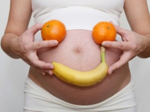 Pregnant Woman Holding Banana and Oranges on Belly